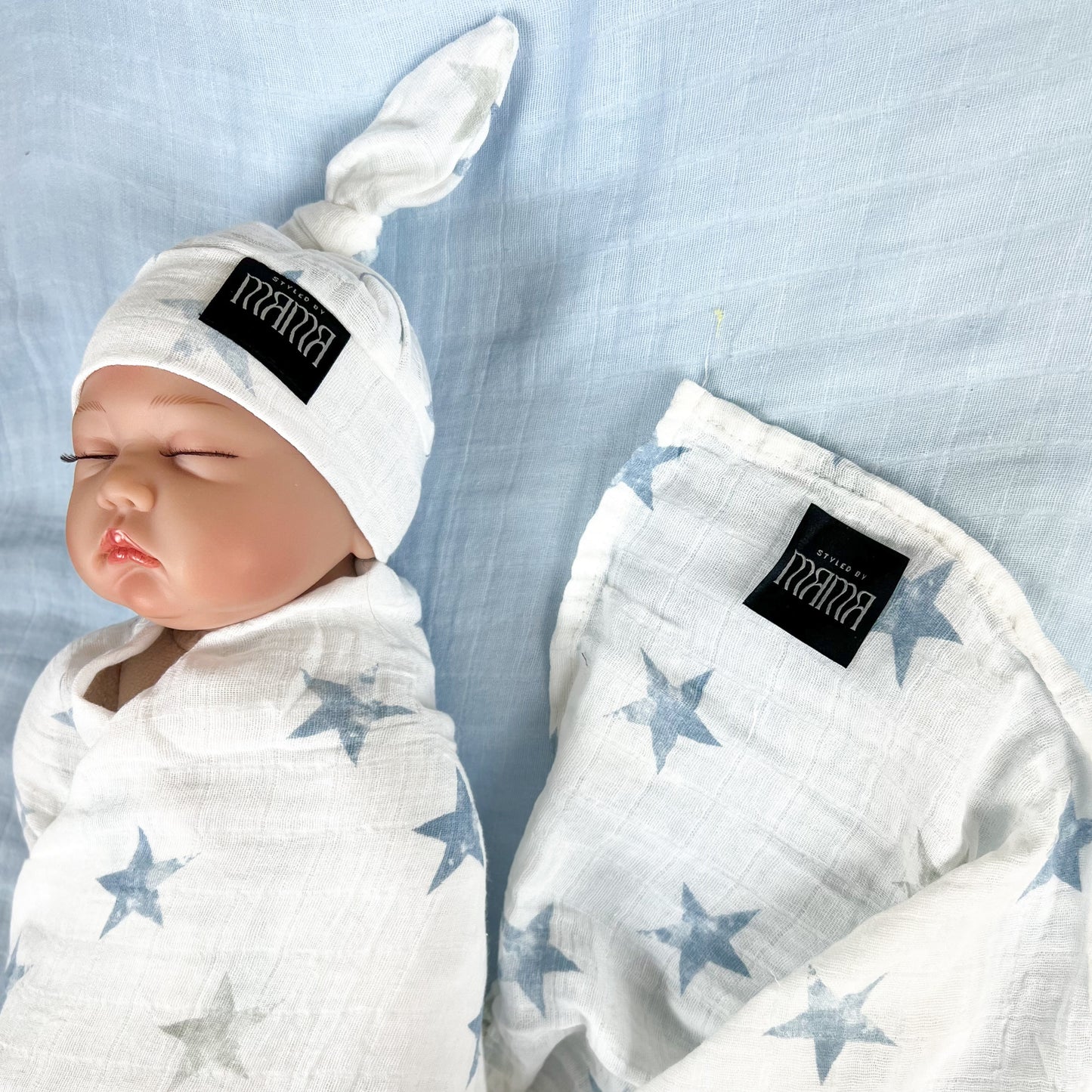 Baby blue stars print muslin organic cotton swaddles styled by mommy and me Arabia