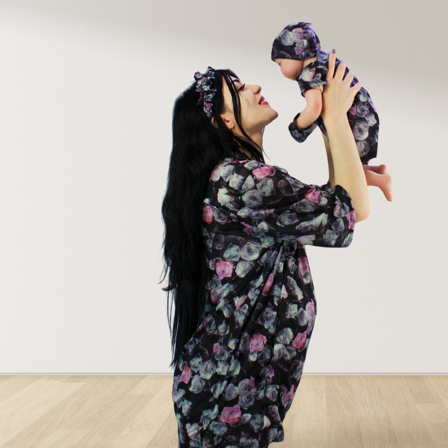 maternity nursing pajama set with baby romper breathable cottoN,mom and baby and wearing a matching pajama set with a floral pattern. The set includes a button-down top with drop shoulders and side buttons for breastfeeding, and matching romper for the baby.made in uae