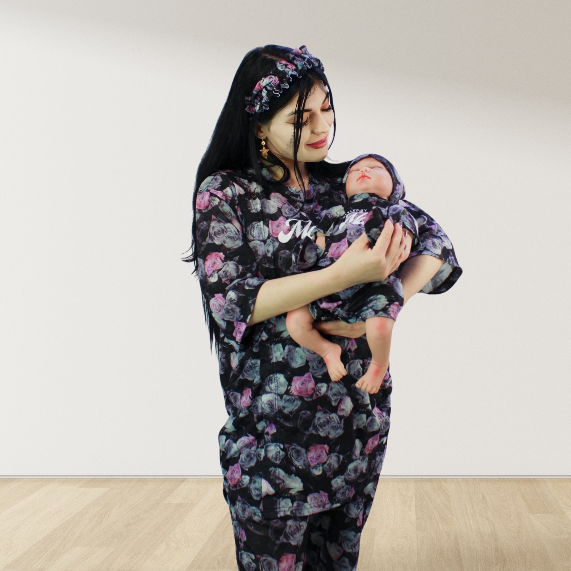 maternity nursing pajama set with baby romper breathable cottoN,mom and baby and wearing a matching pajama set with a floral pattern. The set includes a button-down top with drop shoulders and side buttons for breastfeeding, and matching romper for the baby.made in uae